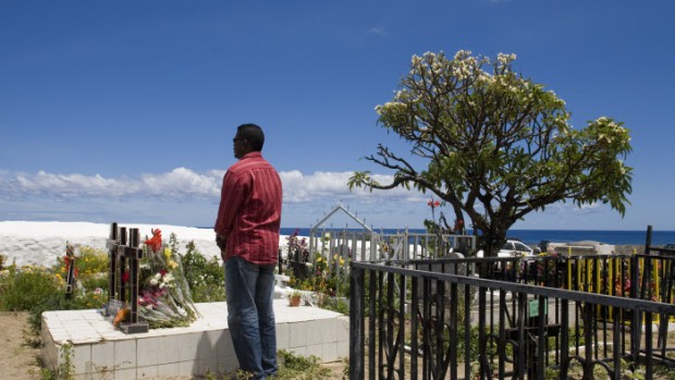 1er Novembre 2007: Homme se recueillant sur une tombe, cimetière de Saint Leu, La Réunion (97), France.